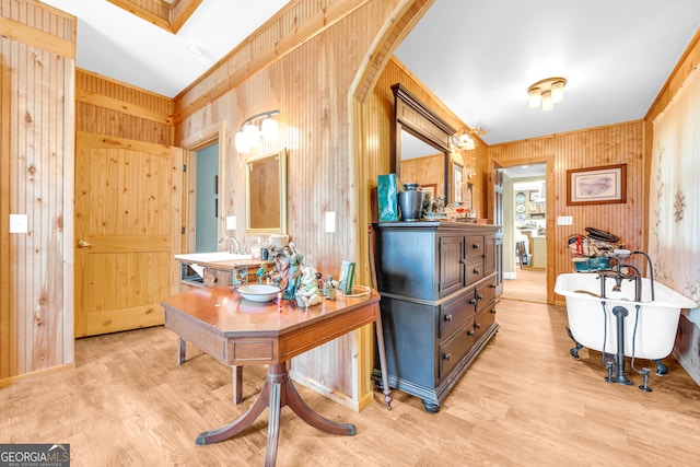 bathroom featuring a soaking tub, wooden walls, vanity, wood finished floors, and baseboards