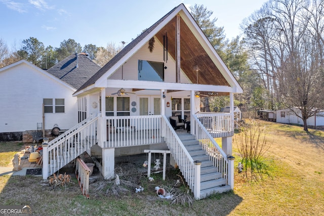 view of front of home with a shingled roof, french doors, and stairs