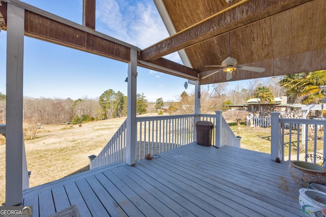 wooden deck featuring ceiling fan and a yard