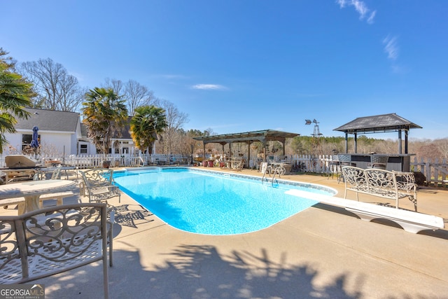 view of pool featuring a pergola, a patio area, fence, and a diving board