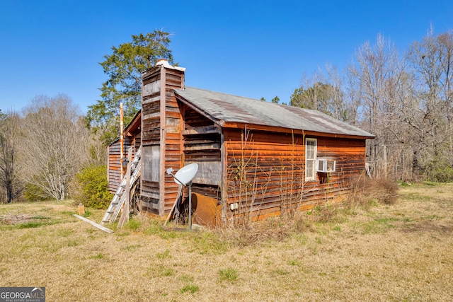 view of side of property with a chimney and an outbuilding