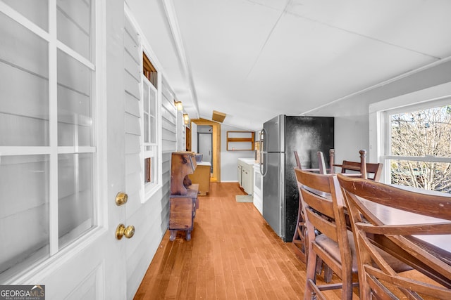 dining area with lofted ceiling and light wood-style flooring