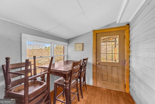 dining room with vaulted ceiling and wood finished floors