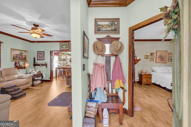 hall with light wood finished floors, baseboards, and crown molding