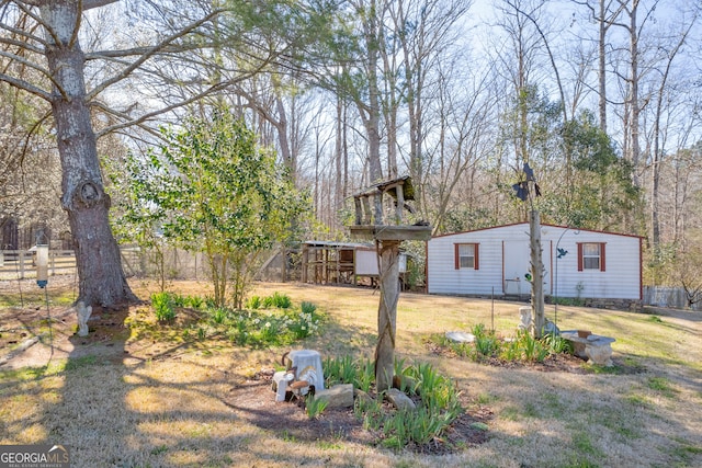 view of yard featuring fence and an outbuilding