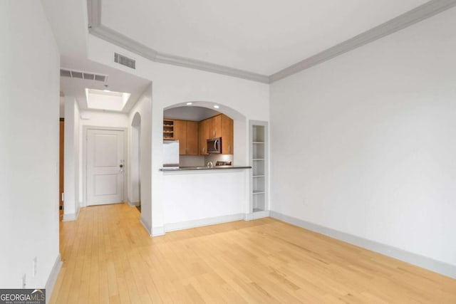 kitchen with visible vents, refrigerator, crown molding, and stainless steel microwave