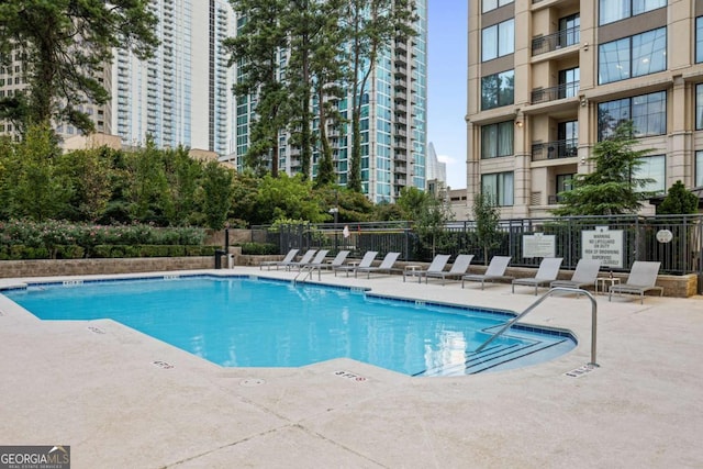 pool with fence and a patio area