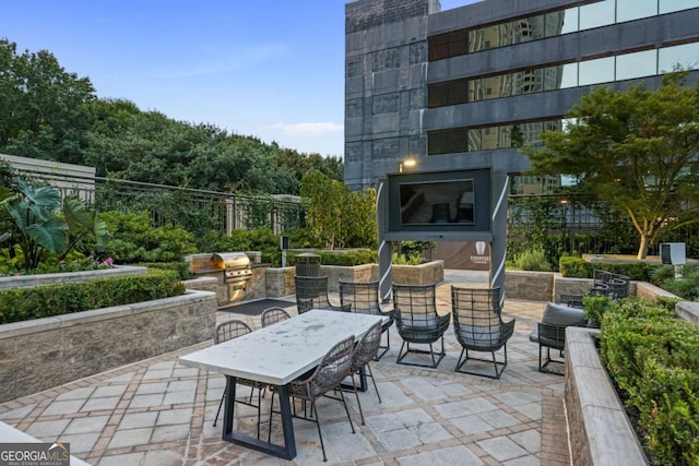 view of patio featuring outdoor dining area, a grill, and exterior kitchen