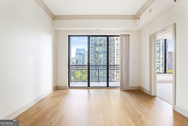 3445 Stratford Rd NE Unit 1605, Atlanta, GA 30326 - spare room featuring ornamental molding, light wood-style flooring, a view of city, and baseboards