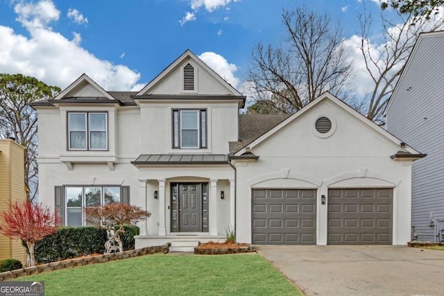 view of front of house featuring stucco siding, concrete driveway, a standing seam roof, a garage, and a front lawn