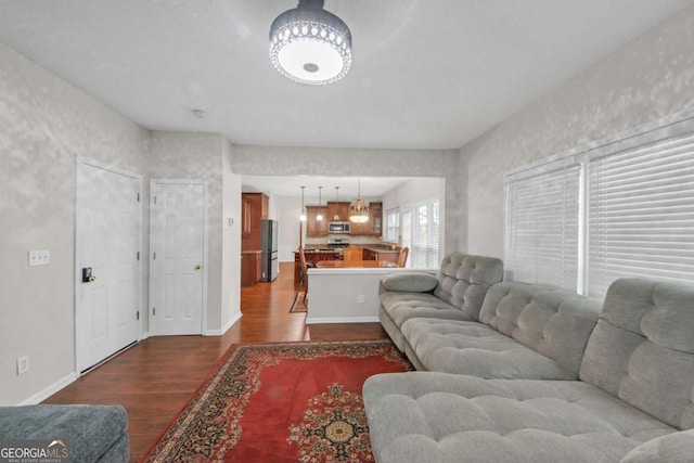 living room featuring baseboards and dark wood finished floors