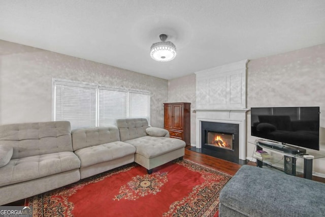 living area featuring a fireplace with flush hearth and wood finished floors