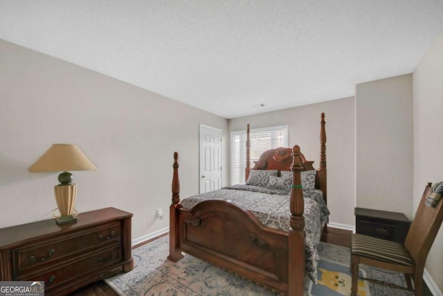 bedroom with baseboards and wood finished floors