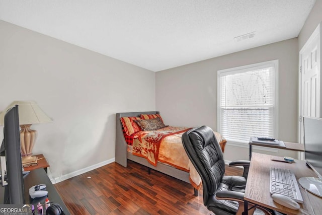 bedroom featuring wood finished floors, visible vents, and baseboards