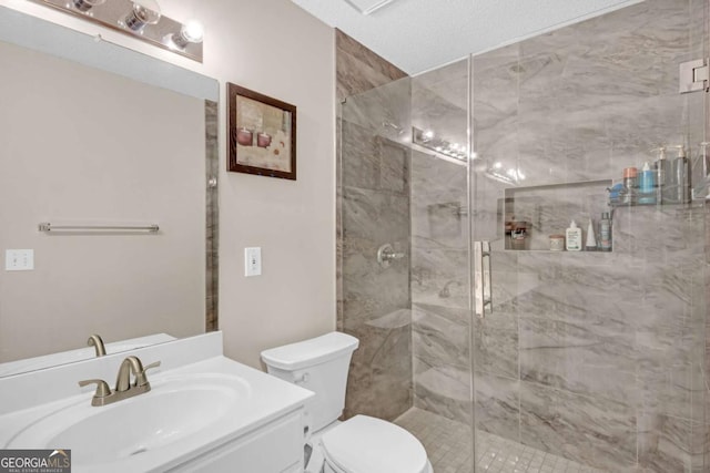 bathroom with a stall shower, vanity, and toilet