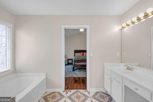 ensuite bathroom featuring a bath, a healthy amount of sunlight, ensuite bathroom, and tile patterned floors