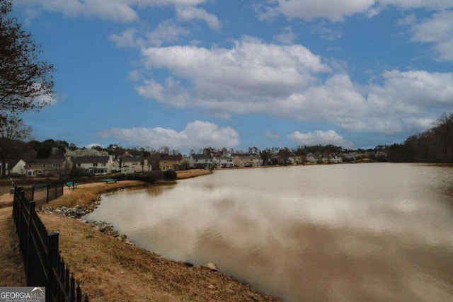 property view of water featuring fence and a residential view