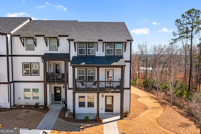 view of property with a shingled roof, a balcony, and board and batten siding