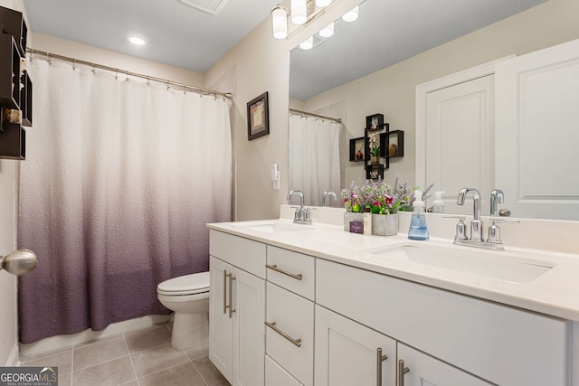 full bathroom featuring double vanity, tile patterned flooring, a sink, and toilet