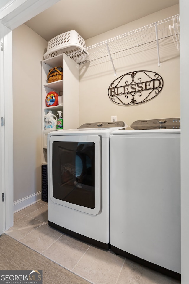 washroom with light tile patterned floors, independent washer and dryer, and baseboards