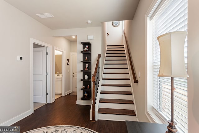 stairway featuring baseboards and wood finished floors