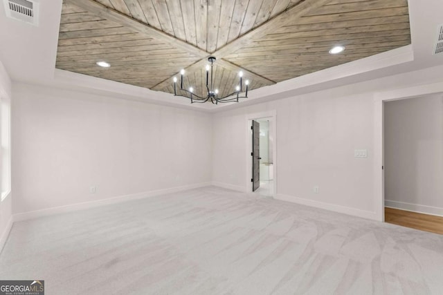 carpeted empty room featuring baseboards, visible vents, wooden ceiling, a tray ceiling, and recessed lighting