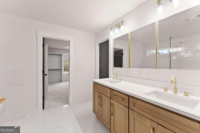 bathroom with double vanity, marble finish floor, visible vents, and a sink