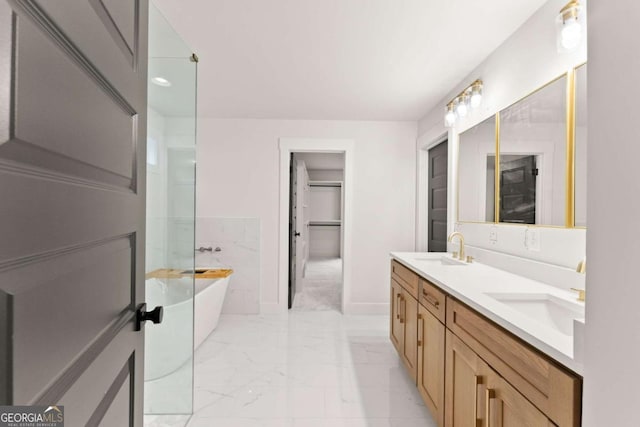 full bathroom with double vanity, marble finish floor, a sink, and a soaking tub