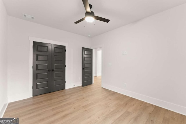 unfurnished bedroom featuring baseboards, visible vents, and light wood finished floors