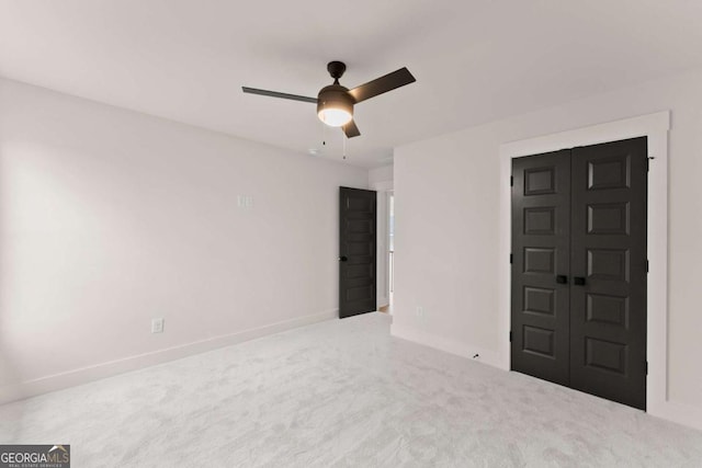 unfurnished bedroom featuring carpet, a closet, ceiling fan, and baseboards