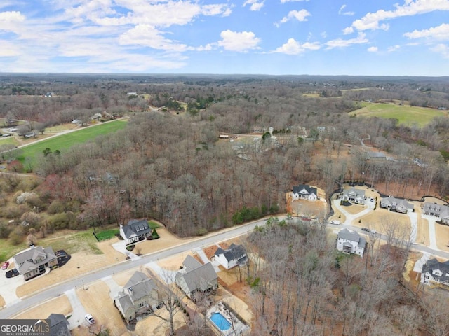 birds eye view of property featuring a wooded view