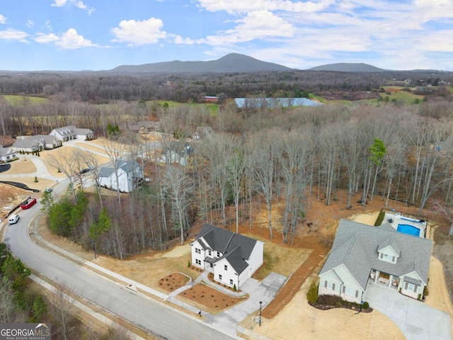 drone / aerial view featuring a forest view and a mountain view