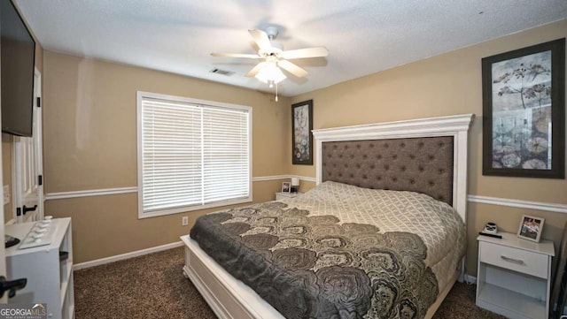 bedroom with ceiling fan, dark carpet, visible vents, and baseboards
