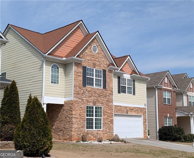 view of front facade featuring stone siding, concrete driveway, and a garage