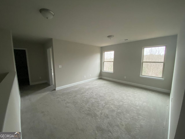 unfurnished room featuring carpet and baseboards