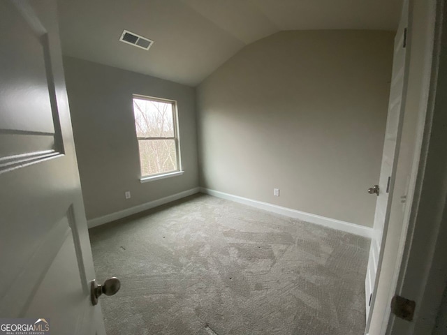 unfurnished bedroom featuring vaulted ceiling, carpet floors, visible vents, and baseboards