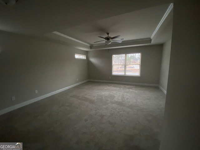 unfurnished room featuring carpet floors, baseboards, a raised ceiling, and a ceiling fan