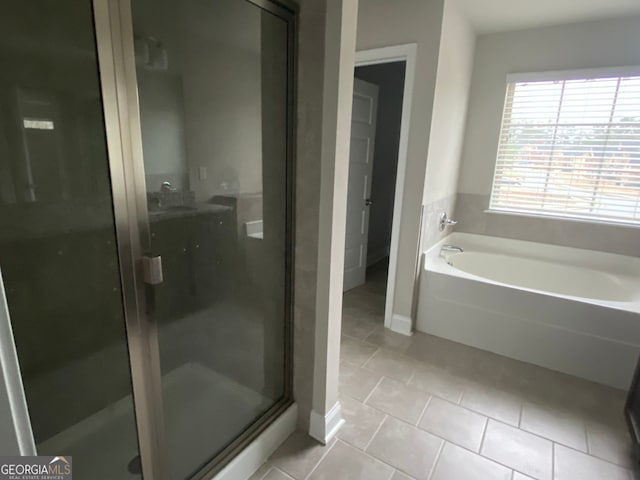 full bath featuring a sink, a shower stall, a bath, and tile patterned floors