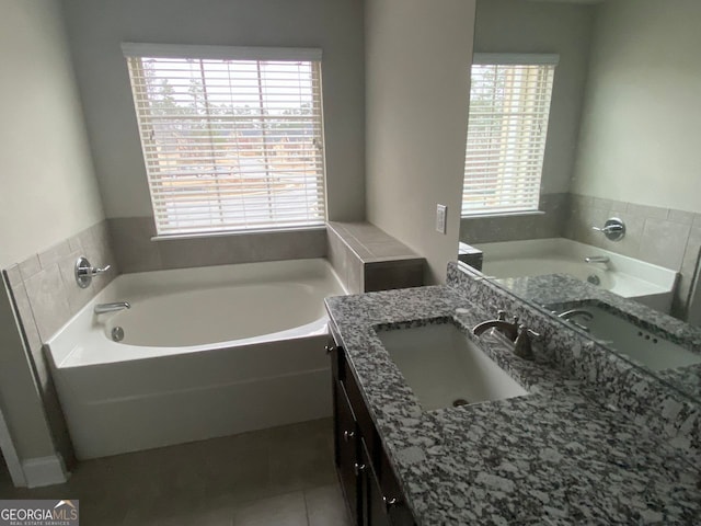 bathroom with vanity, a bath, and tile patterned floors