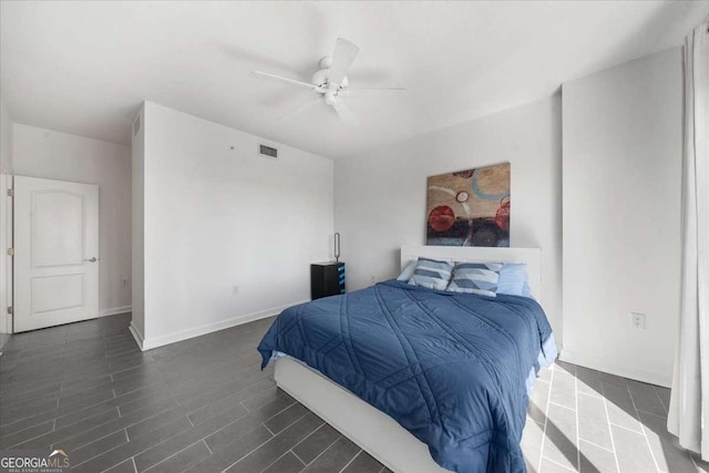 bedroom with baseboards, visible vents, ceiling fan, and dark wood-style flooring