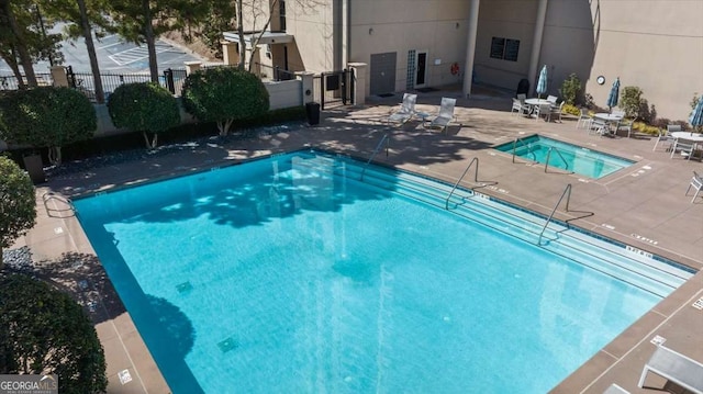 pool with fence and a patio