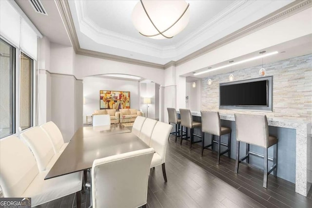 dining room featuring arched walkways, visible vents, ornamental molding, wood tiled floor, and a tray ceiling