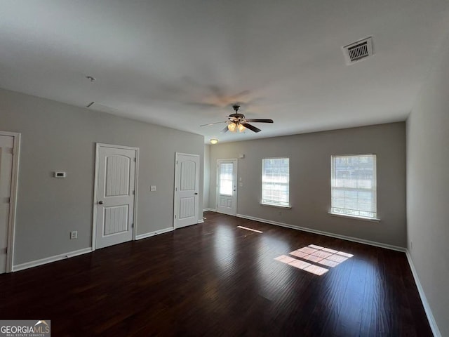 spare room with visible vents, ceiling fan, baseboards, and wood finished floors