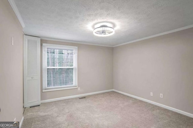 empty room with carpet, baseboards, and a textured ceiling