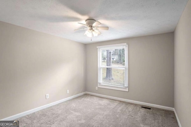 spare room featuring carpet, ceiling fan, a textured ceiling, and baseboards