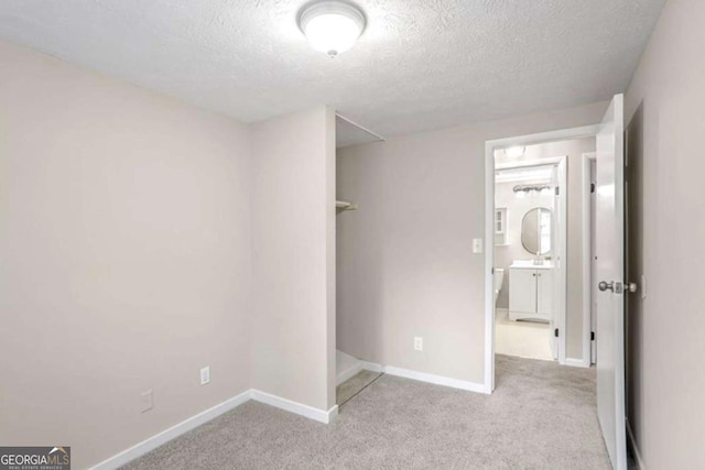 unfurnished bedroom featuring carpet flooring, a textured ceiling, and baseboards