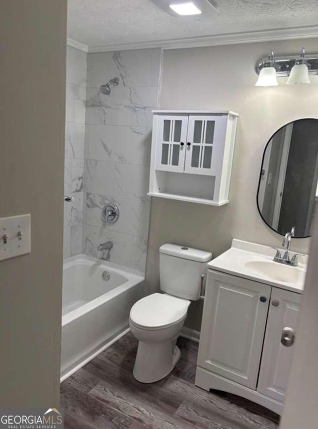 full bath featuring toilet, ornamental molding, a textured ceiling, vanity, and wood finished floors