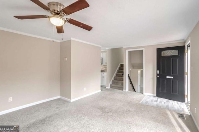 spare room featuring visible vents, stairway, ornamental molding, light carpet, and baseboards