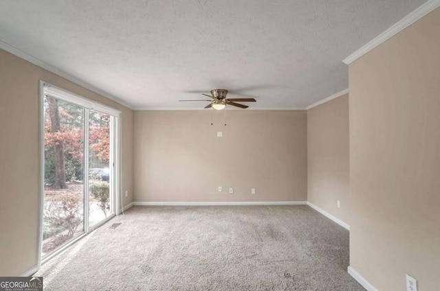 spare room with a textured ceiling, carpet floors, a ceiling fan, baseboards, and crown molding