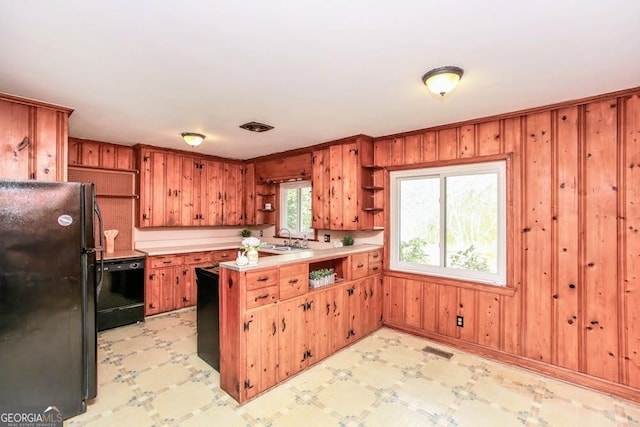 kitchen with light floors, a peninsula, open shelves, light countertops, and black appliances